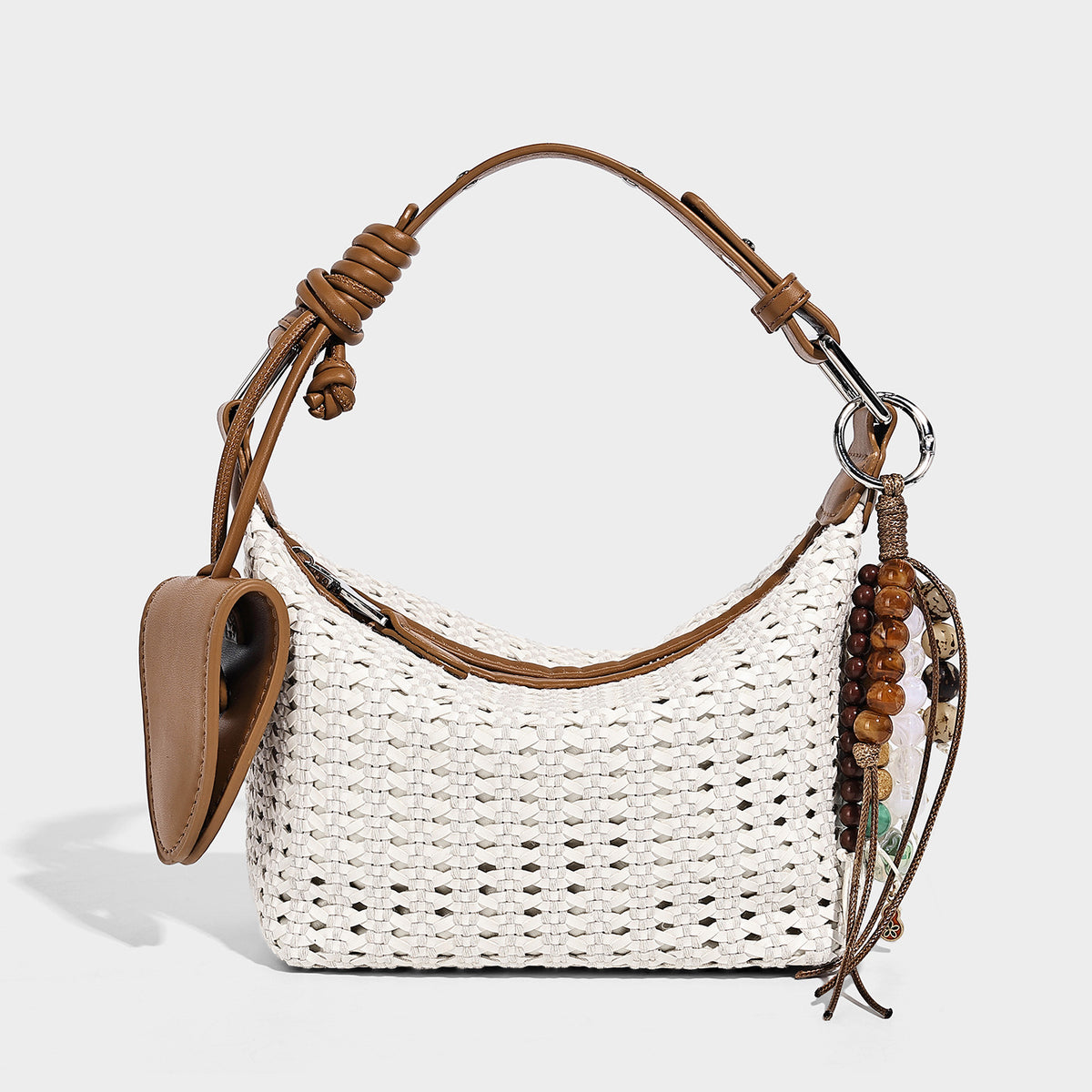 Woven crescent shoulder bag with leather-look knotted handle, zip top, attached mini pouch, and silver-tone hardware, detail