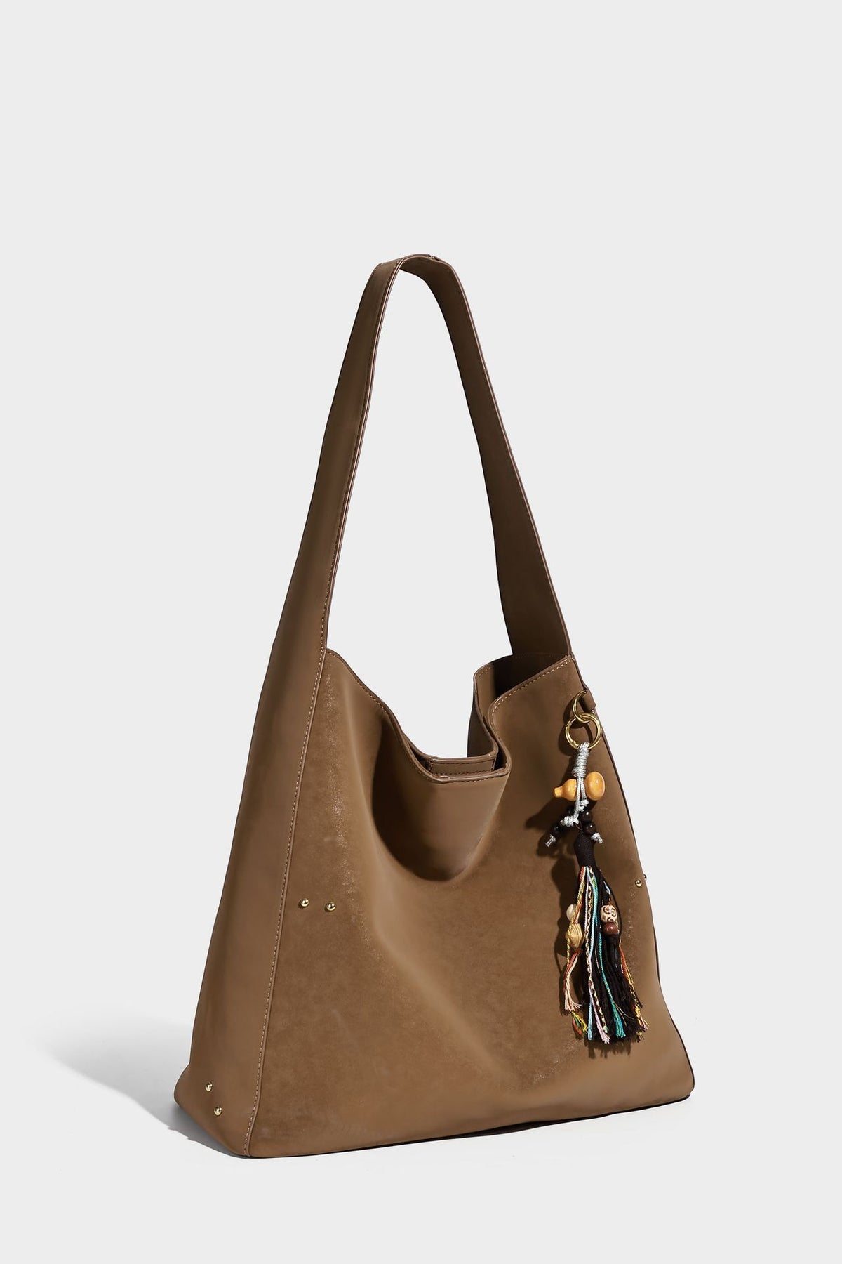 Oversized trapezoid tote bag with matte leather-look finish, gold-tone rivets, and long shoulder strap, detail view 12