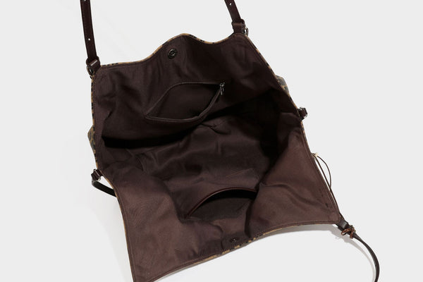 Slouchy leopard-print shoulder tote bag in tan and brown with long double straps, side tie straps, and dangling charm, detail
