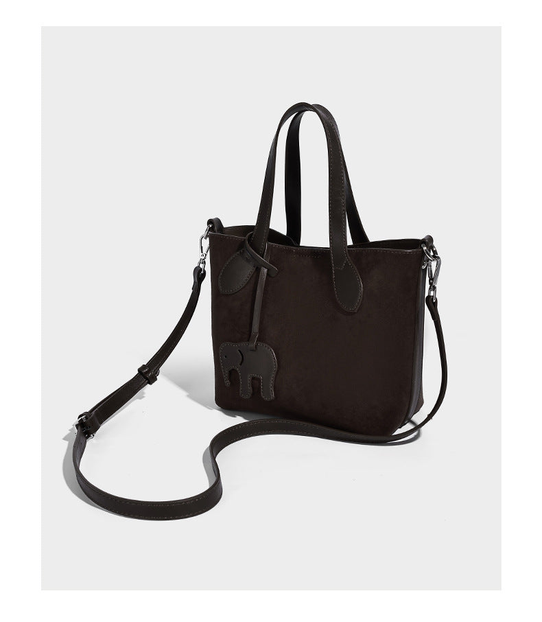 Kleine, strukturierte Tote-Handtasche in Wildlederoptik mit Elefantenanhänger, zwei oberen Tragegriffen und abnehmbarem Crossbody-Riemen, Detailansicht 9