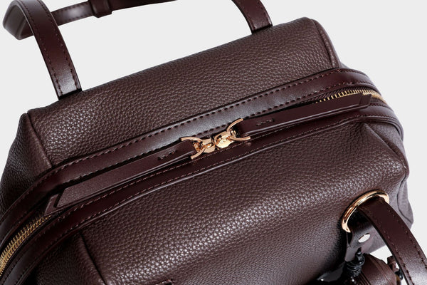 Structured trapezoid shoulder bag in dark brown pebbled leather-look finish with slim double straps, top zip closure, side
