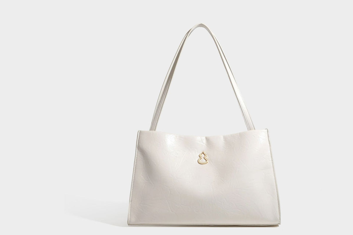 Strukturierte rechteckige Tote-Schultertasche aus glänzender, geknitterter Lederoptik mit langen Doppelträgern und Emblem in Goldoptik