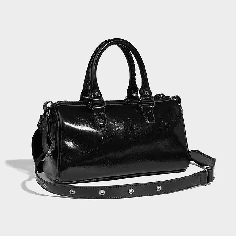 Glossy studded mini satchel bag with braided top handles, front zip pocket, heart charm, and detachable crossbody strap