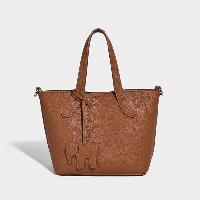 Compact pebbled bucket tote bag with elephant charm, twin top handles, and detachable crossbody strap, detail view 7