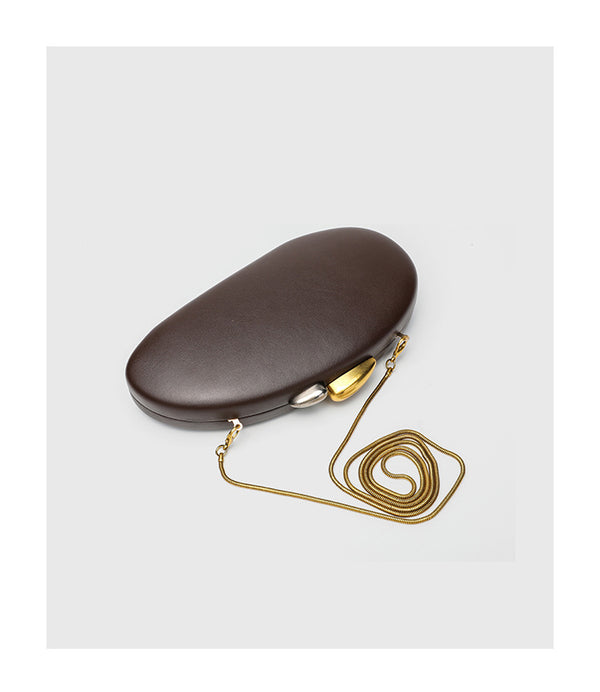 Oval hard-shell crossbody clutch bag with smooth matte leather-look finish and gold-tone snake chain strap, detail view 9