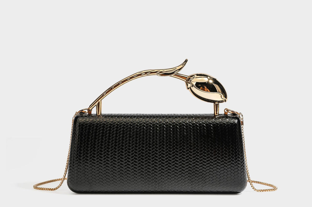 Structured rectangular metallic woven clutch bag with sculptural gold-tone leaf top handle and detachable chain strap, detail