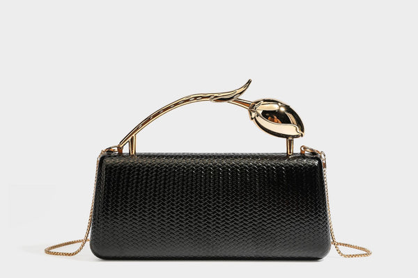Structured rectangular metallic woven clutch bag with sculptural gold-tone leaf top handle and detachable chain strap, detail