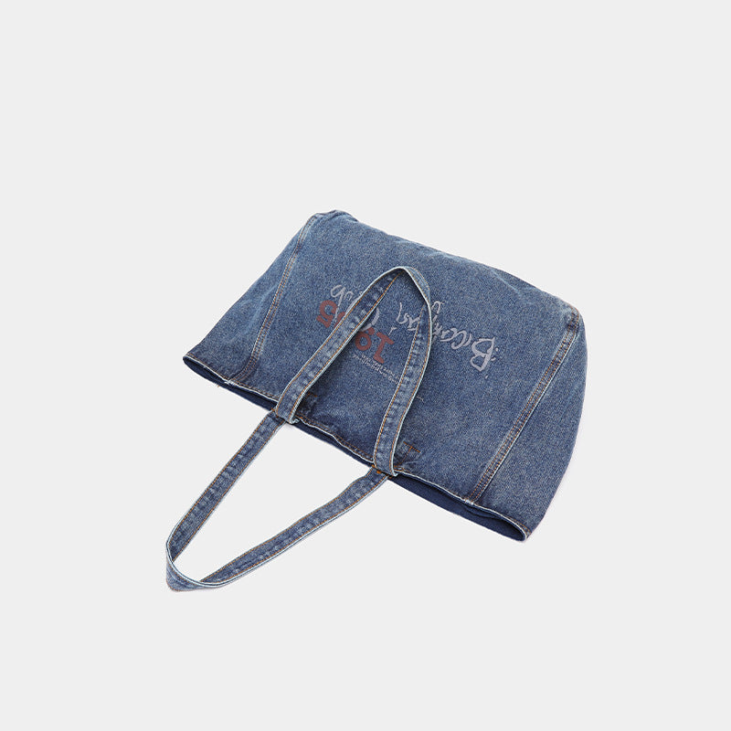Große Tote Bag aus verwaschenem blauem Denim mit Grafikprint im handschriftlichen Stil, orangefarbenen Kontrastnähten und langem Stoffschulterriemen