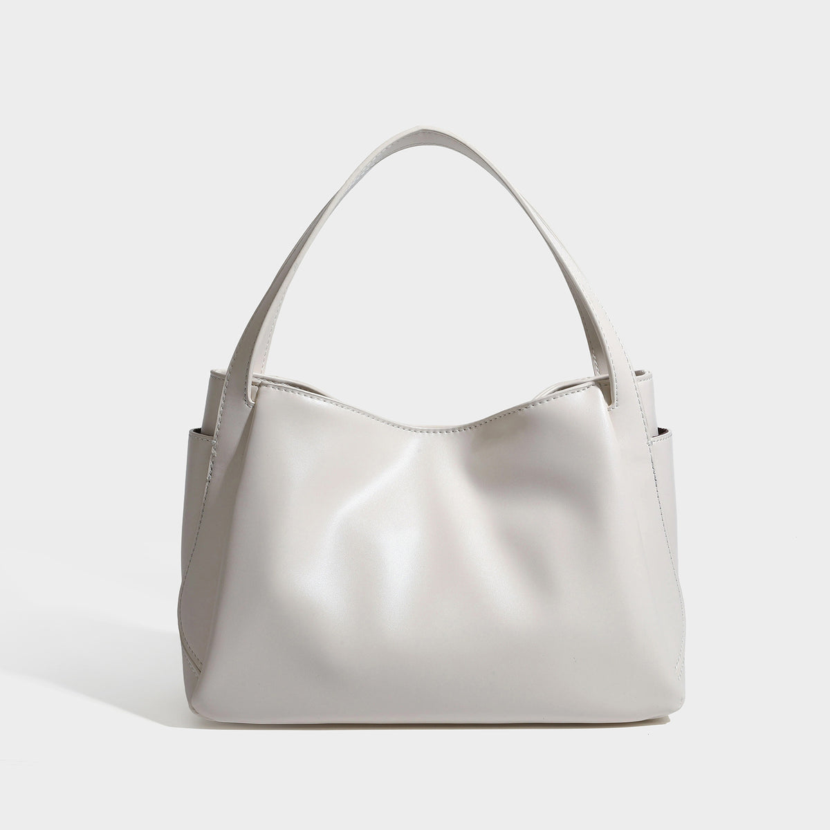 Structured glossy leather-look tote shoulder bag with dual top handles, detachable crossbody strap, side pockets, and, detail