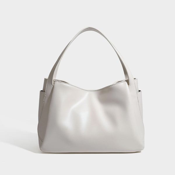 Structured glossy leather-look tote shoulder bag with dual top handles, detachable crossbody strap, side pockets, and, detail