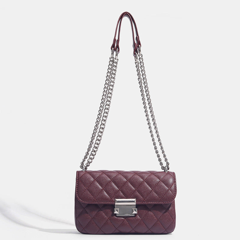 Kleine strukturierte Schultertasche mit Rautensteppung, doppeltem silberfarbenem Kettenriemen und rechteckigem silberfarbenem Verschluss, Detailansicht