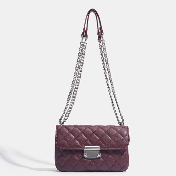 Kleine strukturierte Schultertasche mit Rautensteppung, doppeltem silberfarbenem Kettenriemen und rechteckigem silberfarbenem Verschluss, Detailansicht