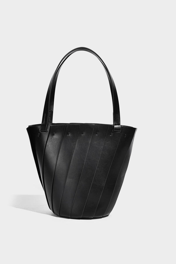 Structured bucket tote bag with vertical panel exterior, dual top handles, and detachable shoulder strap in tan leather-look