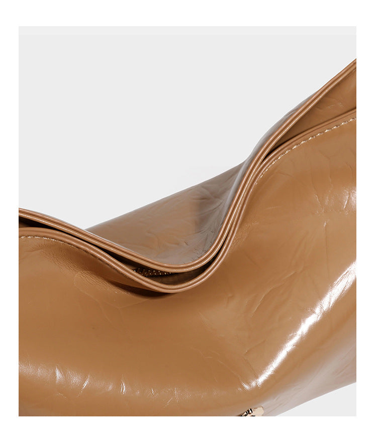 Lässige Hobo-Schultertasche mit offenem oberen Abschluss in glänzender karamellfarbener Lederoptik mit goldfarbenen Logo-Beschlägen und langem, verstellbarem