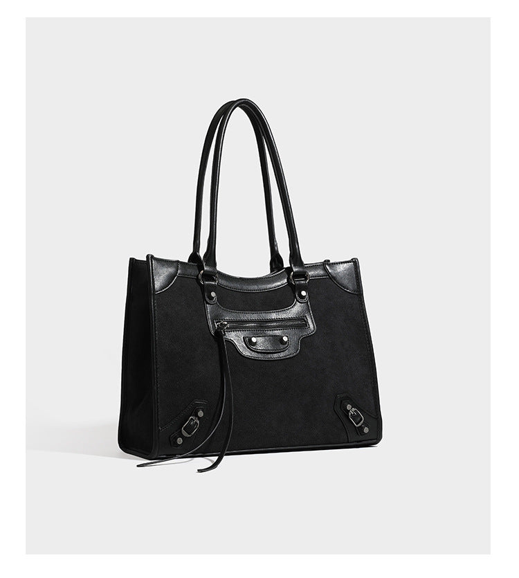 Large structured tote bag with matte suede-like body, smooth leather-look trim, front zip pocket, stud hardware, and
