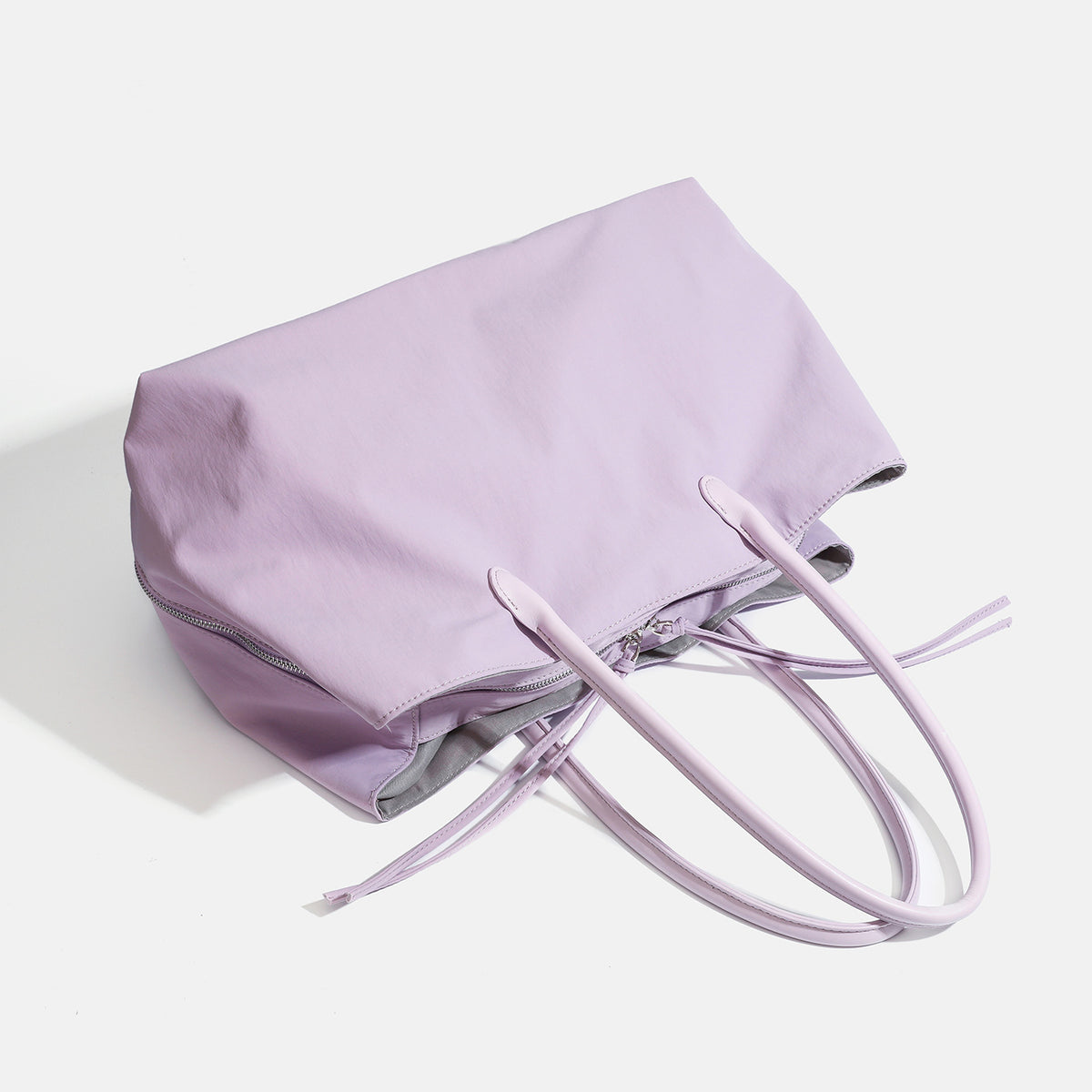 Large soft nylon tote bag with long double handles and zippered top in lavender, detail view 4