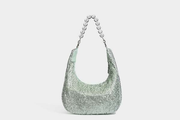 Kleine sichelförmige Schultertasche mit vollständig mit silberfarbenen Pailletten besetzter Außenseite, transparentem Henkel aus kugelförmigen Perlen und Reißverschluss in Silberoptik