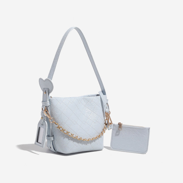 Small diamond-quilted bucket bag with gold-tone chain accent, heart strap detail, hanging tag, and matching zip coin pouch