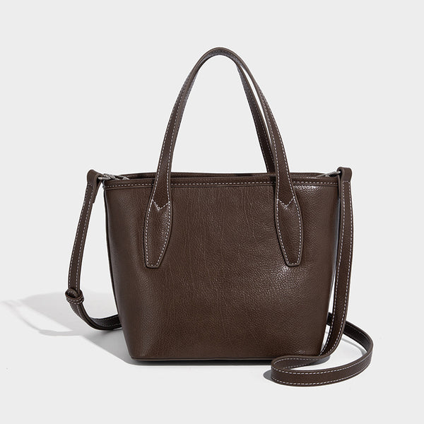 Compact structured bucket tote bag with pebbled textured finish, dual top handles, silver-tone lock hardware, and detachable