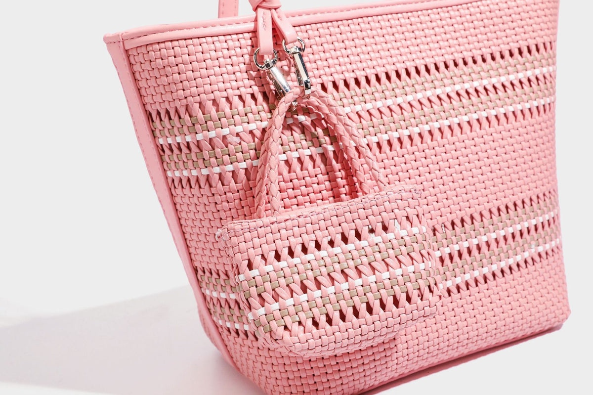 Large structured woven tote bag with striped basket-weave finish, long shoulder straps, and detachable mini pouch charm