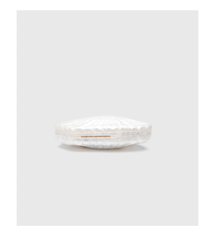 Oval pearl-finish shell clutch bag with gold-tone clasp and removable gold link chain strap, detail view 9