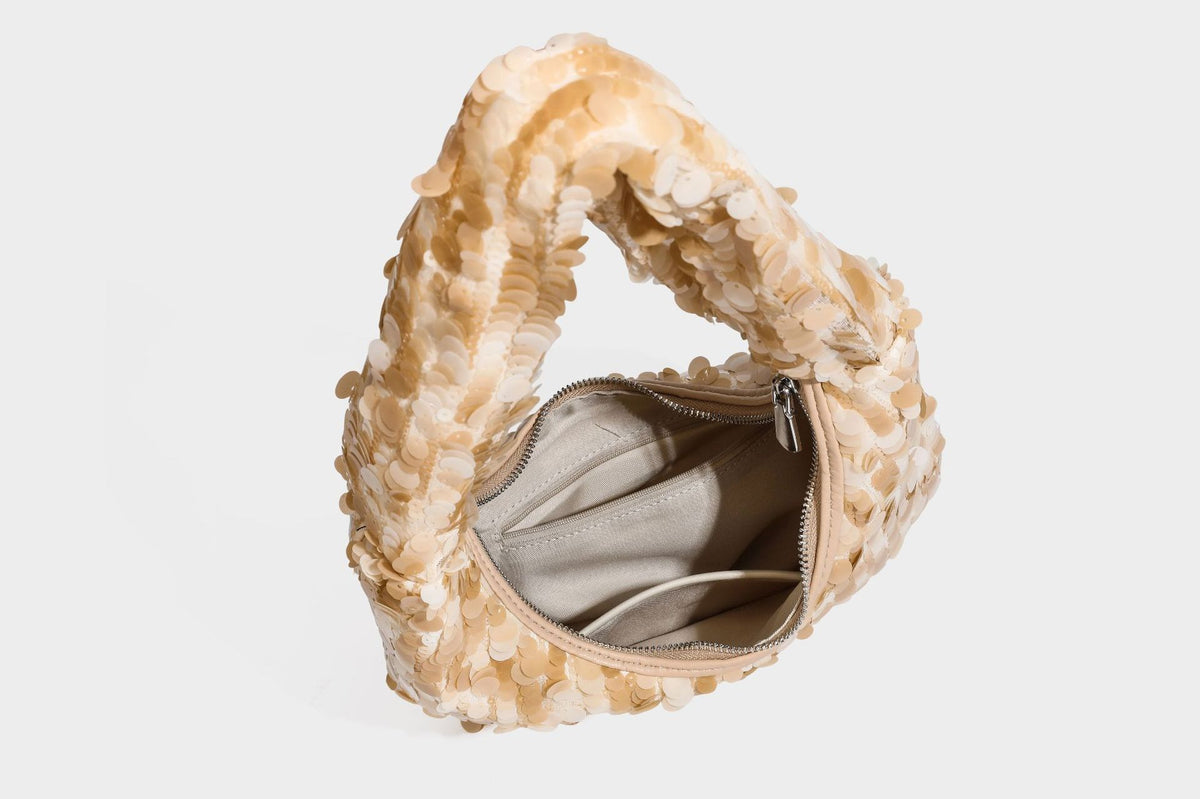 Slouchy crescent hobo shoulder bag covered in overlapping reflective sequin discs with a single integrated strap and top-zip