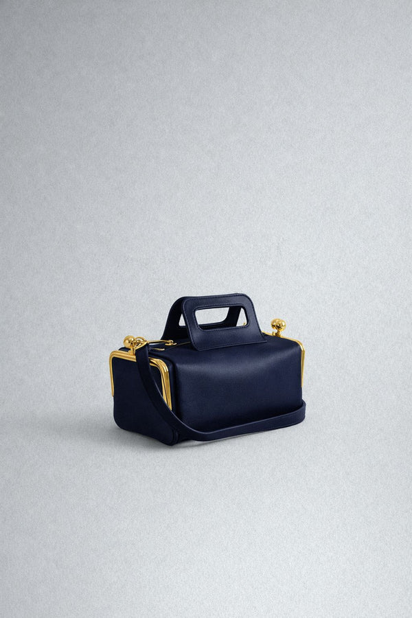Kompakte dunkelbraune Henkeltasche in Lederoptik mit goldfarbenem Rahmenbeschlag und abnehmbarem, verstellbarem Crossbody-Riemen