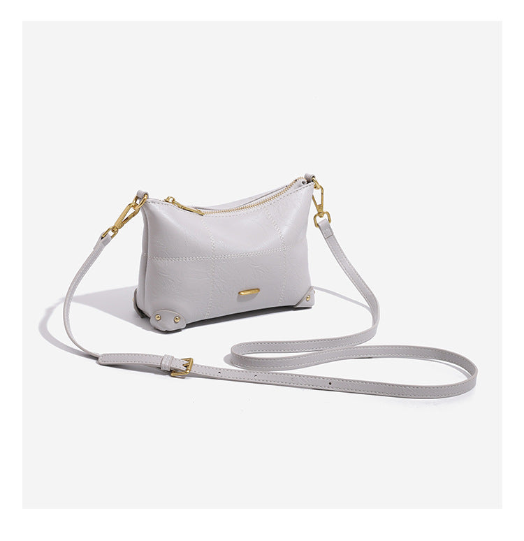 Small soft-structured shoulder bag with curved zip closure, stitched panel detailing, and gold-tone hardware, detail view 9