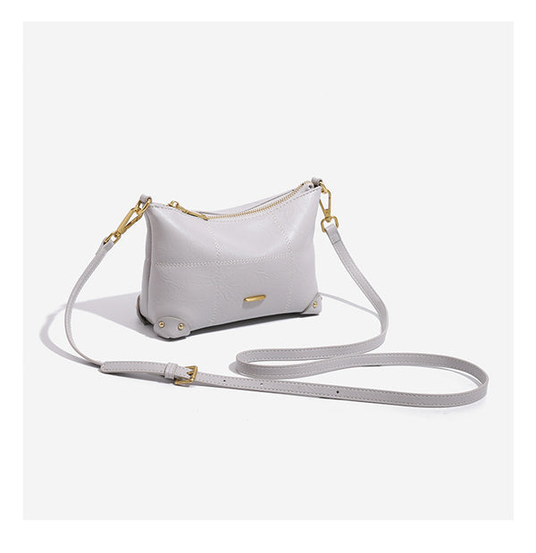 Small soft-structured shoulder bag with curved zip closure, stitched panel detailing, and gold-tone hardware, detail view 9