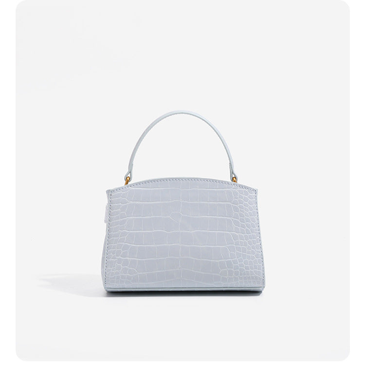Small structured crocodile-embossed top-handle bag with gold-tone turn-lock closure and detachable shoulder strap, detail
