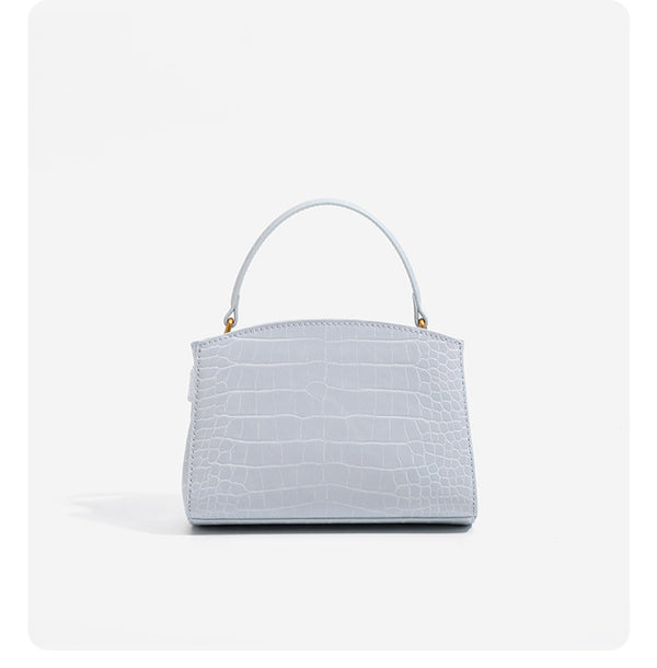 Small structured crocodile-embossed top-handle bag with gold-tone turn-lock closure and detachable shoulder strap, detail