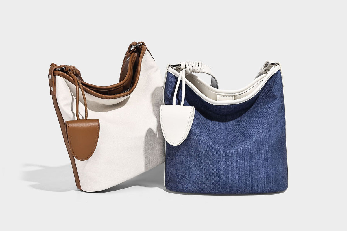 Große Bucket-Schultertasche aus Canvas in Denim-Optik mit Besatz in weißer Lederoptik, geknotetem Riemen und abnehmbarer Mini-Tasche auf der Vorderseite