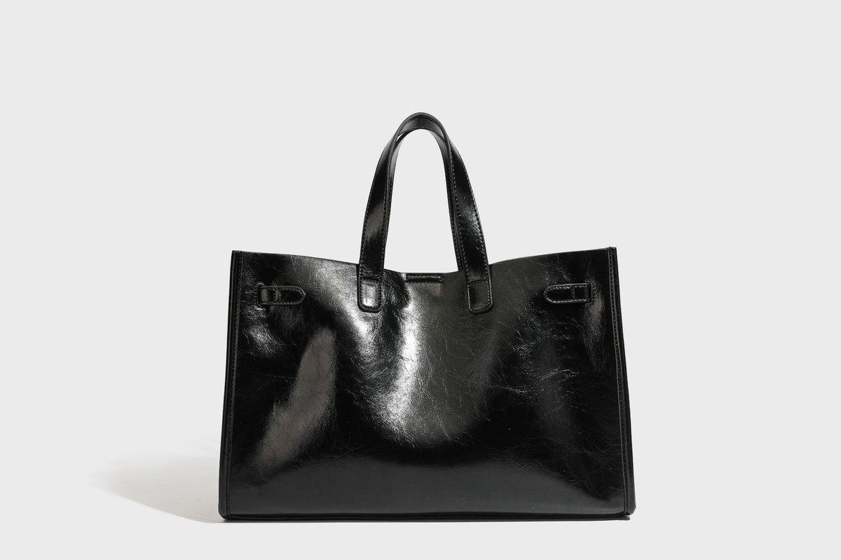 Strukturierte, glänzende Tote-Bag in Lederoptik mit silberfarbenem Drehverschluss, zwei Tragegriffen und abnehmbarem Schulterriemen, Detailansicht