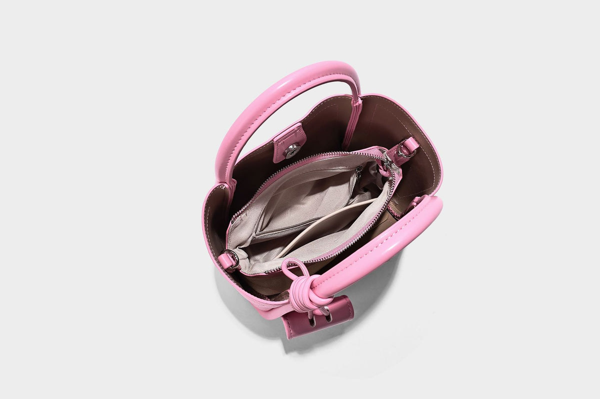 Structured mini tote bag in pebbled leather-look finish with knotted top handles, front flap pocket, and detachable shoulder