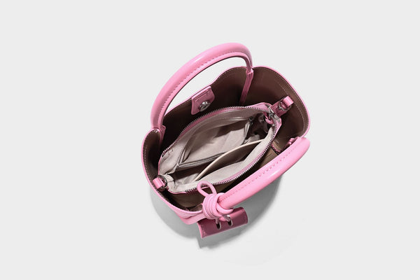 Structured mini tote bag in pebbled leather-look finish with knotted top handles, front flap pocket, and detachable shoulder