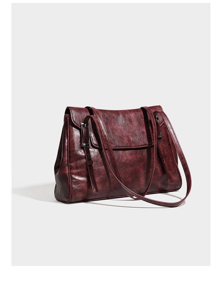 Large structured shoulder tote bag in wine red textured leather-look finish with front flap closure and silver-tone buckle