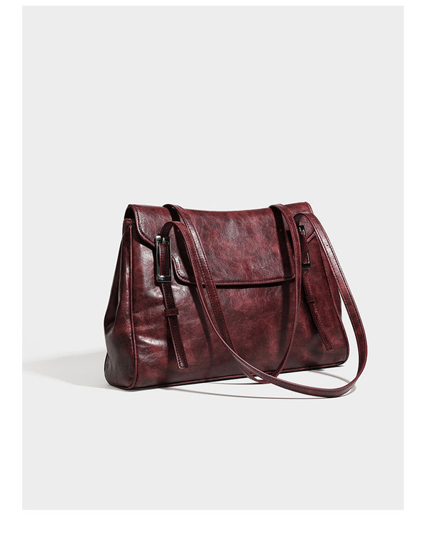 Large structured shoulder tote bag in wine red textured leather-look finish with front flap closure and silver-tone buckle