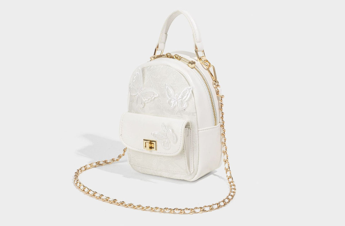 Structured mini backpack handbag with butterfly embroidery, gold-tone chain strap, and turn-lock front flap pocket, detail