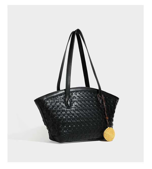 Large leather-look tote bag with geometric woven emboss, double shoulder straps, and round woven cord charm in brown, detail