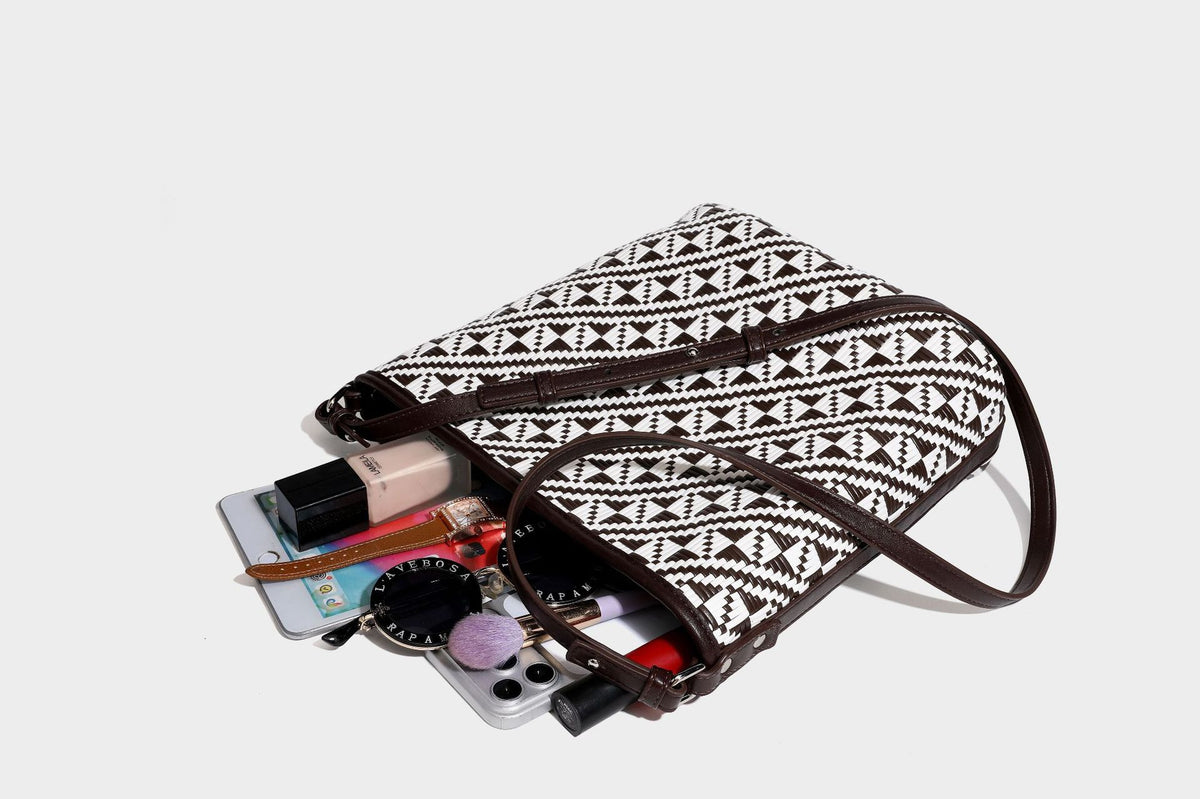 Geflochtene Schultertasche mit geometrischem Ethno-Muster, Besatz in dunkelbrauner Lederoptik, langem verstellbarem Träger und kleinem hängendem Reißverschluss