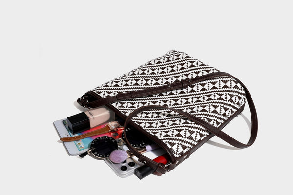 Geflochtene Schultertasche mit geometrischem Ethno-Muster, Besatz in dunkelbrauner Lederoptik, langem verstellbarem Träger und kleinem hängendem Reißverschluss
