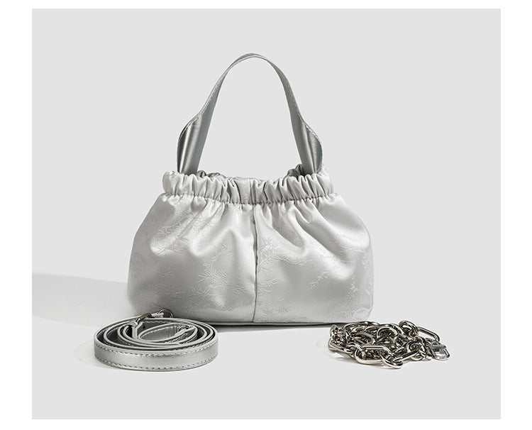 Small ruched satin-finish cloud bag with elasticized drawstring top, short top handle, and chunky silver-tone chain strap