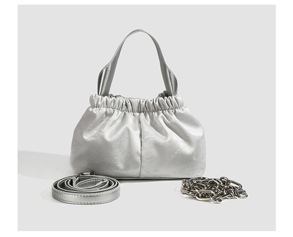 Small ruched satin-finish cloud bag with elasticized drawstring top, short top handle, and chunky silver-tone chain strap
