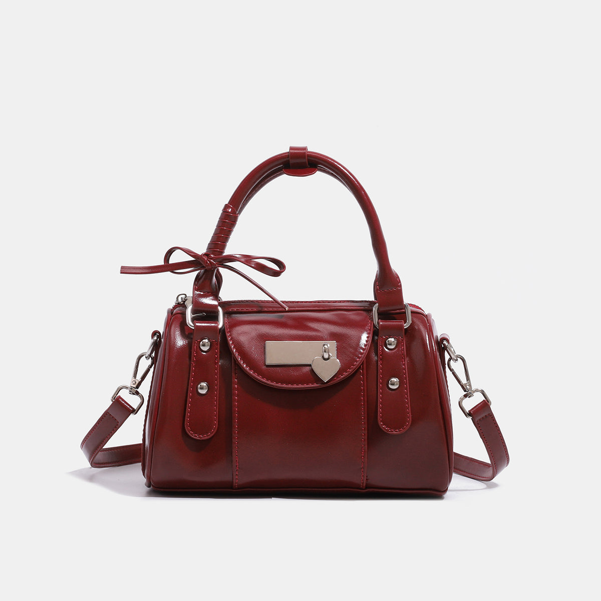 Kleine strukturierte Henkeltasche mit glänzender Oberfläche, zwei Tragegriffen, aufgesetzter Fronttasche, herzförmigem Verschlussanhänger und silberfarbenem