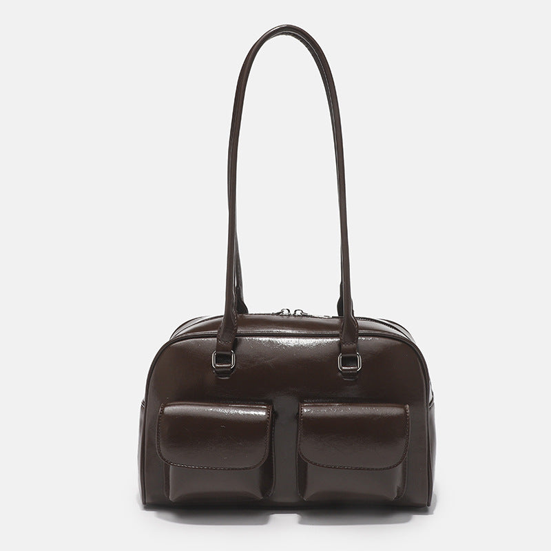 Structured glossy leather-look bowling shoulder bag with two front flap pockets, top zip closure, and long double shoulder