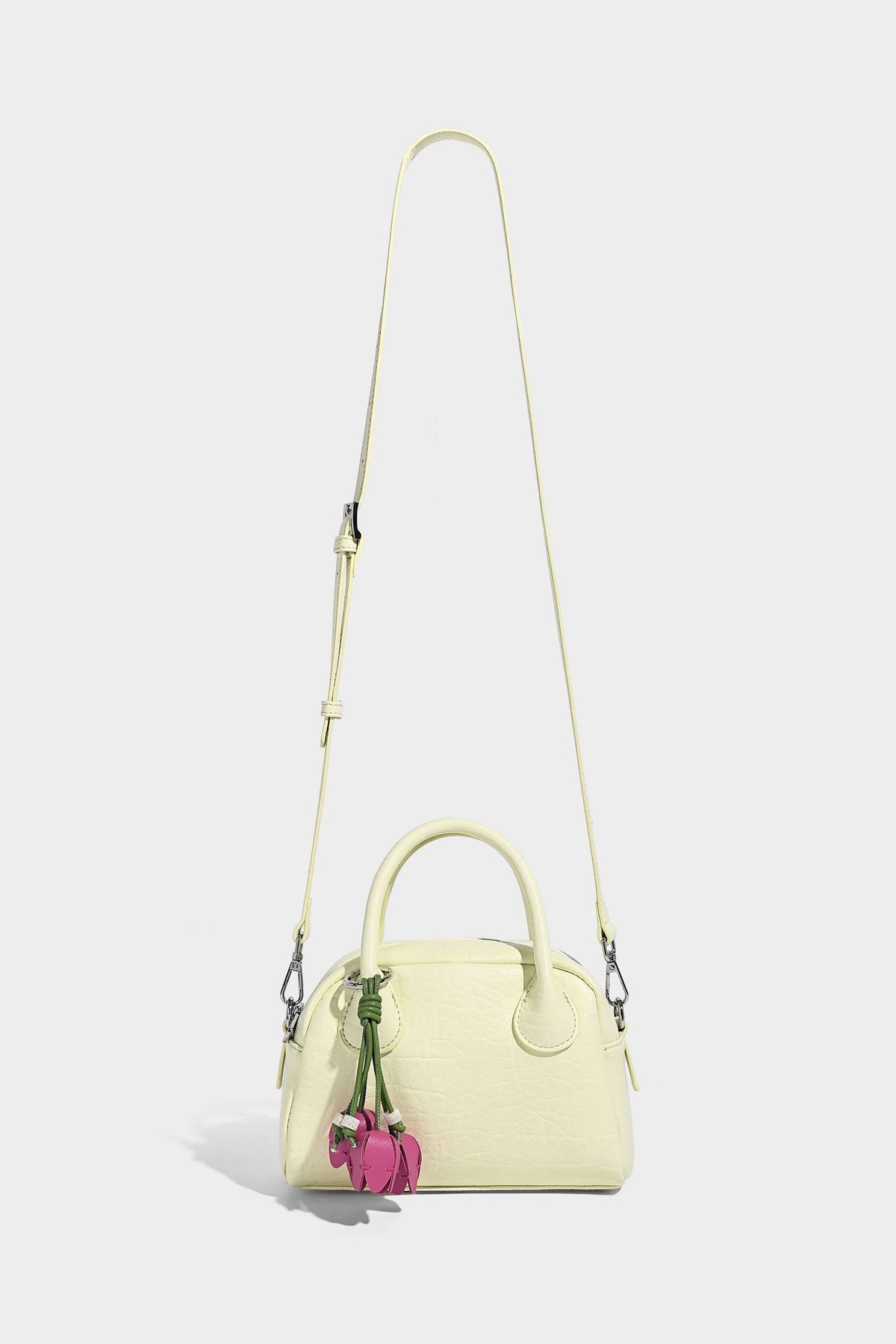 Mini-Tasche mit strukturierter Kuppelform und Tragegriff, in Pastellgelb mit genarbter Lederoptik, silberfarbenen Metallbeschlägen und abnehmbarem