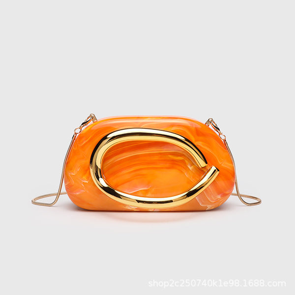 Kleine rechteckige Crossbody-Clutch mit abgerundeten Ecken, oversized poliertem C-förmigem Goldgriff und schmalem Goldkettenriemen, Detailansicht