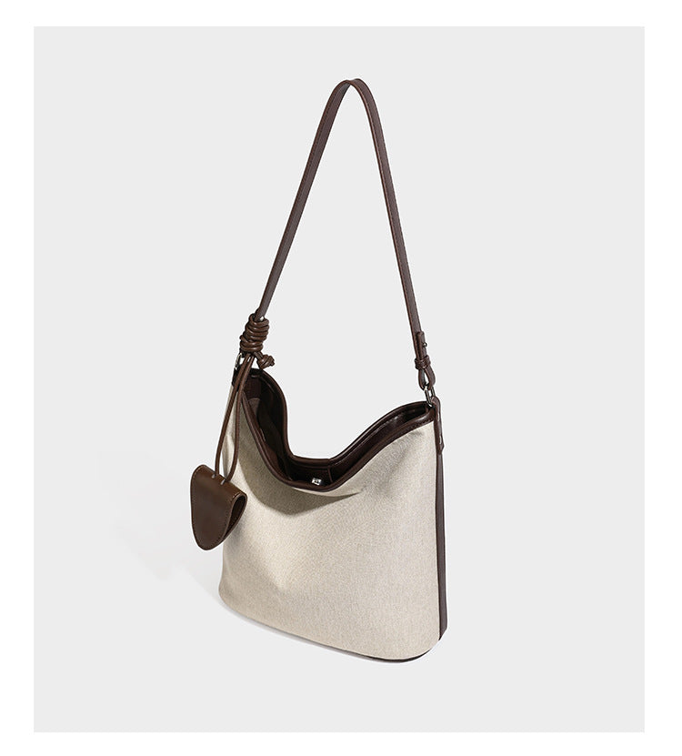 Cremefarbene Canvas-Schultertasche im Beuteltaschen-Stil mit dunkelbraunen Details in Lederoptik, geknotetem Riemen und befestigtem Mini-Etui, Detailansicht 10