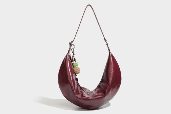 Lässig fallende Hobo-Schultertasche in Halbmondform mit glänzender, geknautschter Lederoptik, schmalem Riemen, silberfarbenen Ringbeschlägen und