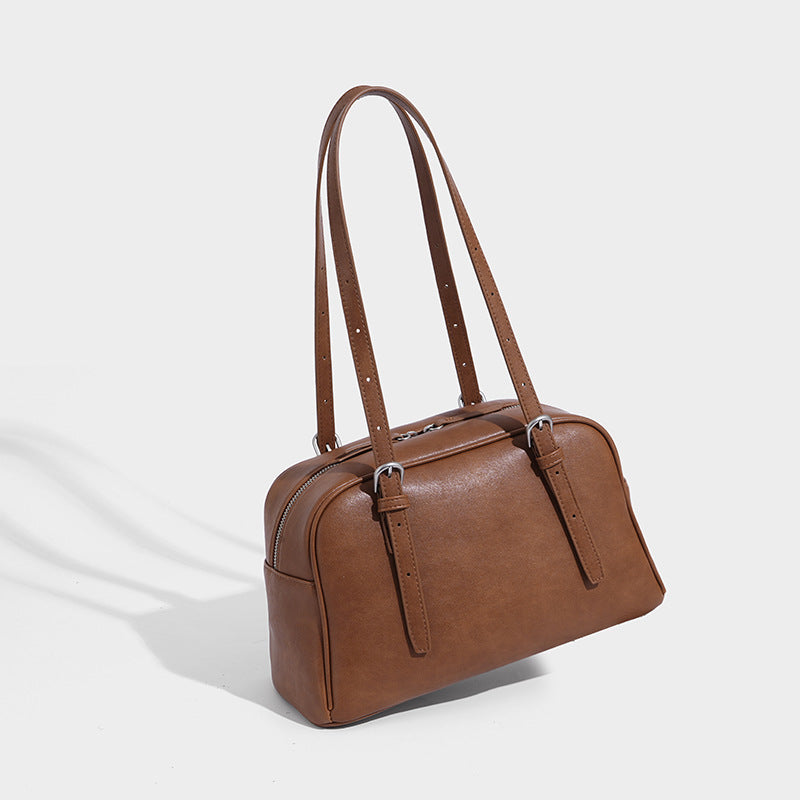 Structured dome-shaped shoulder bag with leather-look finish, top zipper closure, dual adjustable slim straps, and, detail